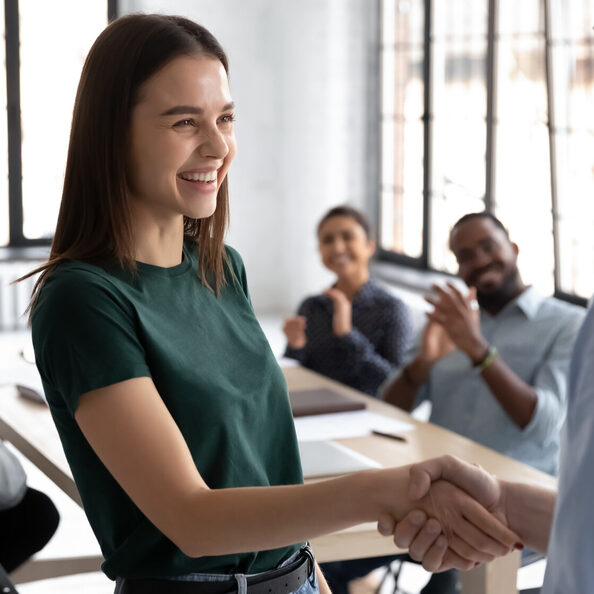 Male boss handshake female employee greeting with success at meeting