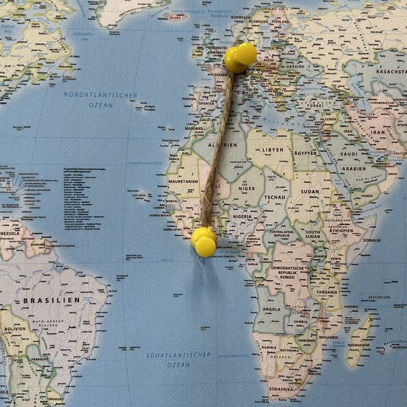 Ausschnitt aus einer Weltkarte. In der Region La Mé und dem Kreis Düren stecken jeweils ein Pin. Die beiden Pins sind mit einer Schnur verbunden.