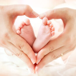 Motivbild Hand mit Babyfüßen [Foto: © Romolo Tavani, stock.adobe.com]