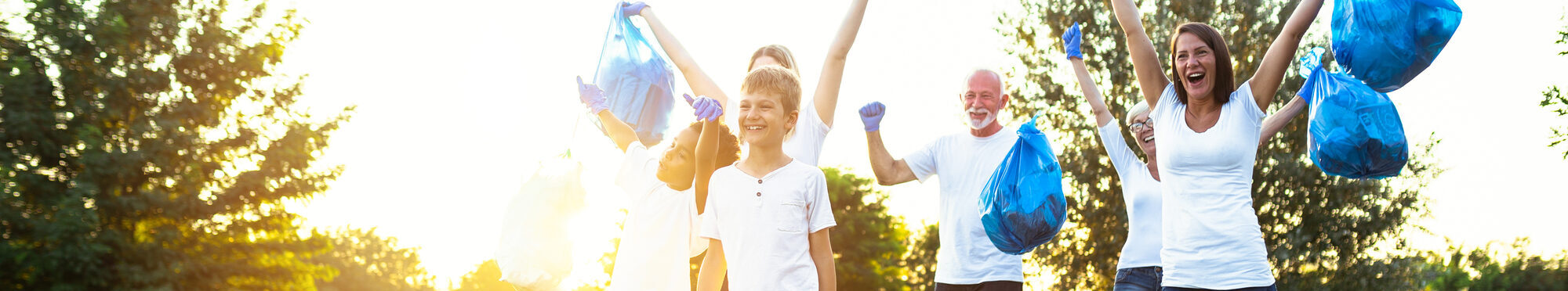 Volunteers with garbage bags cleaning up garbage outdoors - ecology concept.