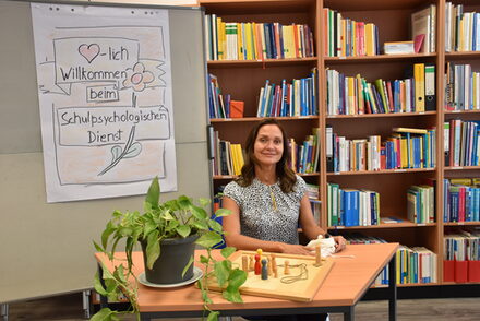 Marla Consalter leitet den Schulpsychologischen Dienst und sitzt im Büro vor einer Bücherwand.