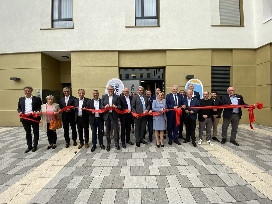 Landrat Wolfgang Spelthahn schnitt zur Eröffnung des Welcome-Centers mit zahlreichen Bürgermeistern aus dem Kreisgebiet sowie weiteren Gästen symbolisch ein rotes Band durch.