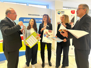 Landrat Dr. Ralf Nolten unterhält sich mit Kolleginnen aus dem Kreishaus sowie dem Sparkassen-Chef Uwe Willner über den Familienplaner.