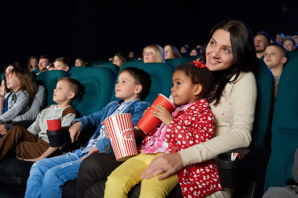 Children with parents enjoying a movie together at the cinema