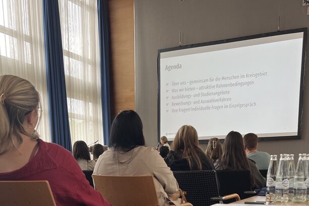 Schlüsselbänder im Vordergrund vor dem vollen Saal am Kreiskarrieretag
