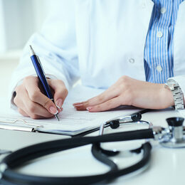 Mid section of female doctor writes prescription to patient at worktable. Panacea and life save, prescribing treatment.