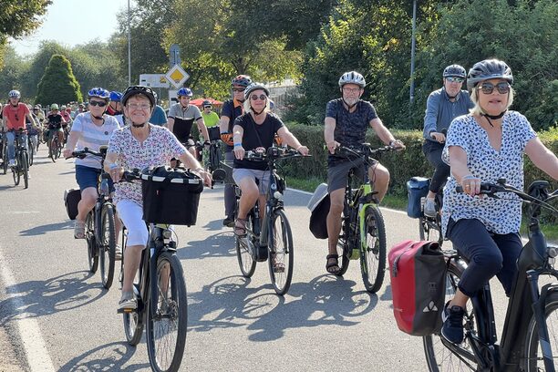 Das Bild zeigt mehrere Radfahrerinnen und Radfahrer auf der Straße