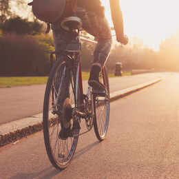 Young woman cycling in the park at sunset