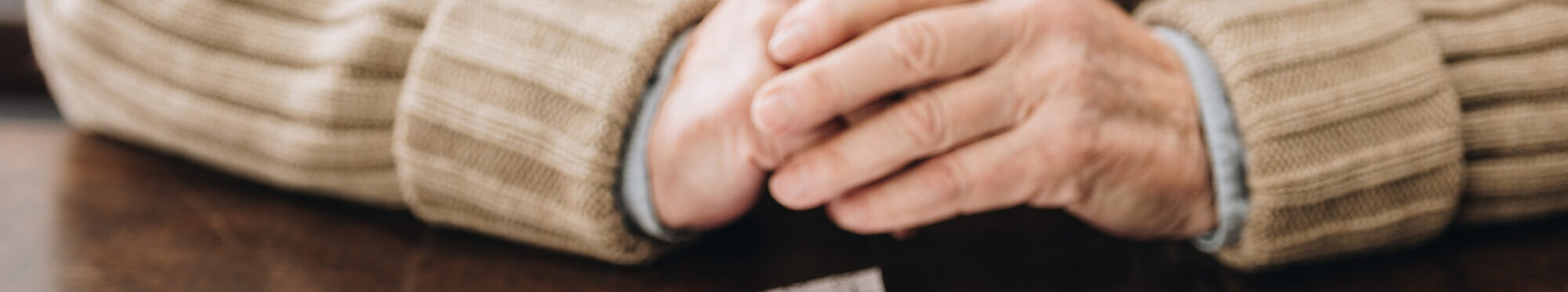 cropped view of senior man playing with puzzles on table