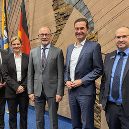 Das Bild zeigt eine Frau und vier Männer im Sitzungssaal des Kreishauses