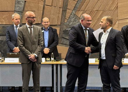 Das Bild zeigt mehrere Männer, der neue Landrat gratuliert einem seiner Stellvertreter