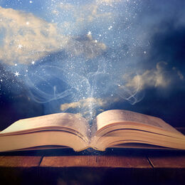 image of open antique book on wooden table with glitter overlay.